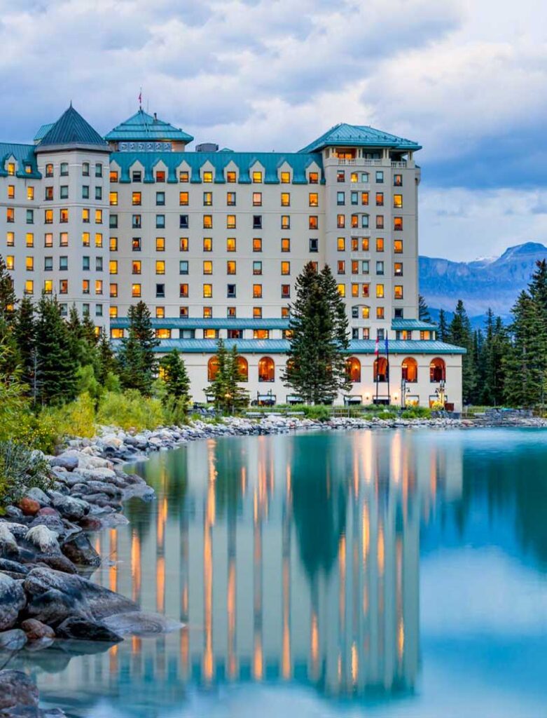 Fairmont Chateau Lake Louise, an iconic luxury mountain resort nestled in Alberta's Banff National Park. Surrounded by majestic mountain peaks, the glistening Victoria Glacier, and the serene emerald lake, it stands as a timeless retreat in the heart of nature.