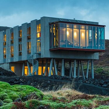 A stunning view of the Ion Hotel nestled in Iceland's breathtaking natural surroundings, offering a luxurious retreat for travelers on a self-flying journey through the country
