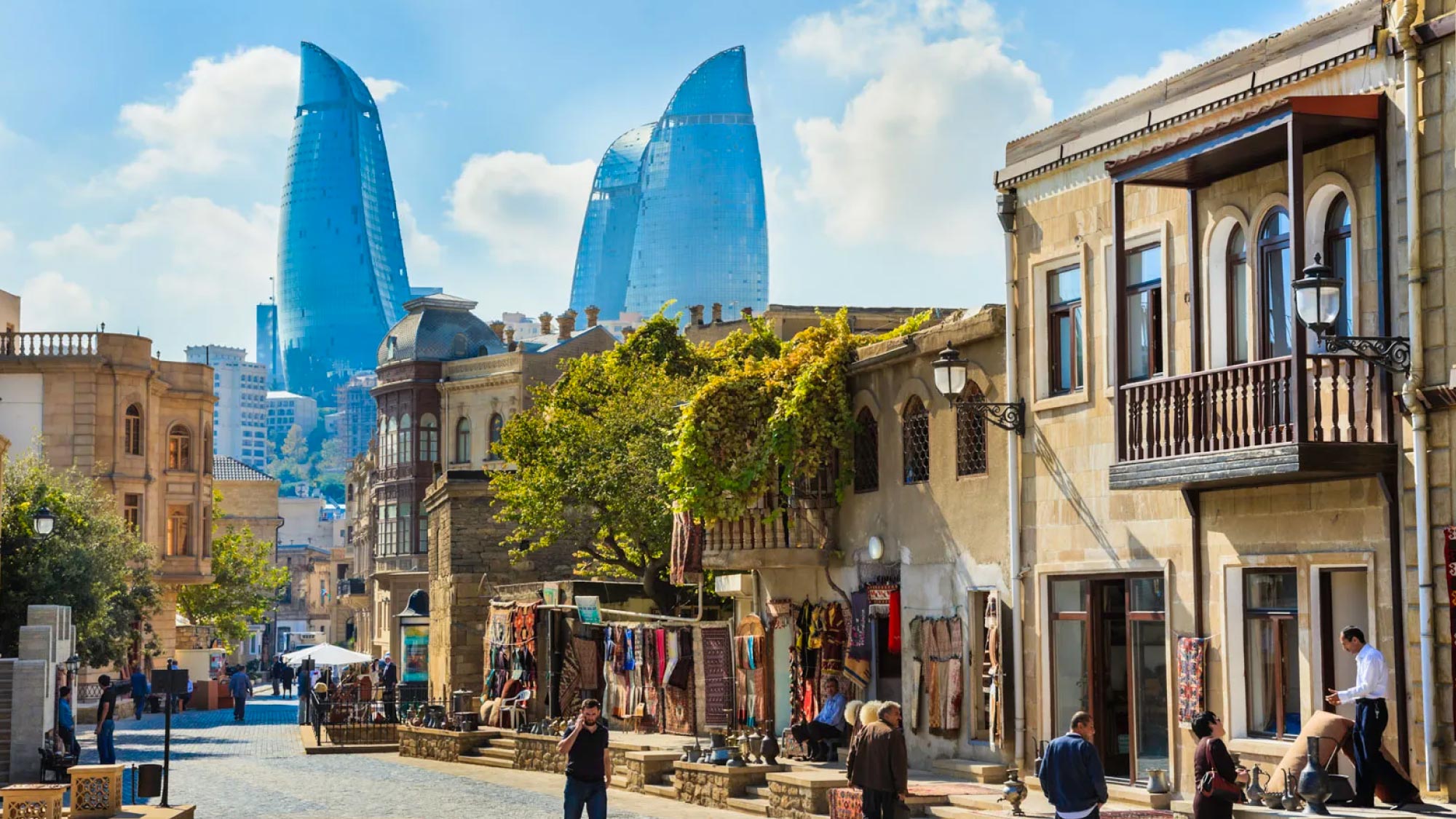 A picturesque view of the cityscape of Baku, Azerbaijan, featuring modern skyscrapers juxtaposed against historic buildings and the Caspian Sea. Baku is a highlight of a journey to Australia, visiting 21 countries, ideal for travelers who fly and own their own airplanes.