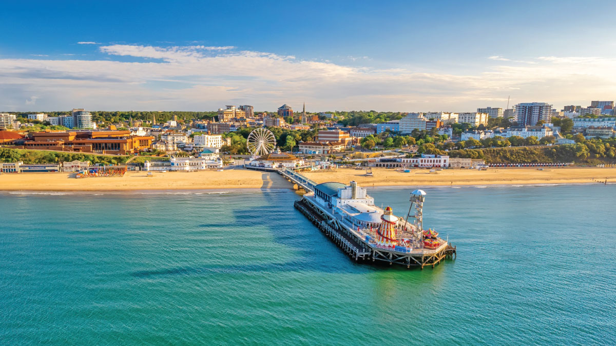Panoramic view of Bournemouth, England, captivating self-flying pilots with their own aircraft, showcasing the picturesque coastline, iconic pier, and bustling theme park, promising an exhilarating start to their European adventure.