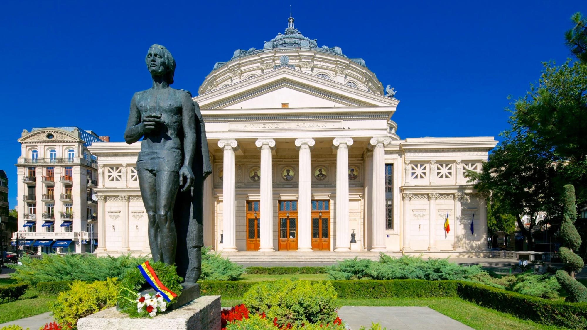 A charming view of the cityscape of Bucharest, Romania, showcasing a blend of historic architecture, tree-lined boulevards, and modern buildings. Bucharest is a highlight of a journey to Australia, visiting 21 countries, perfect for travelers who fly and own their own airplanes.