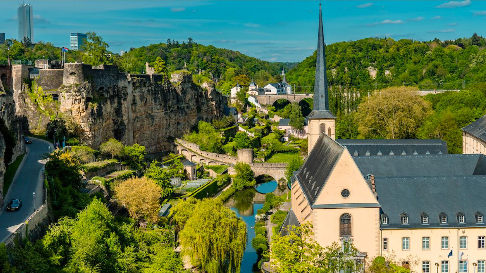 A picturesque view of Luxembourg City, featuring its iconic medieval fortifications, historic buildings, and lush greenery. Luxembourg is a highlight of a journey to Australia, visiting 21 countries, ideal for travelers who fly and own their own airplanes.