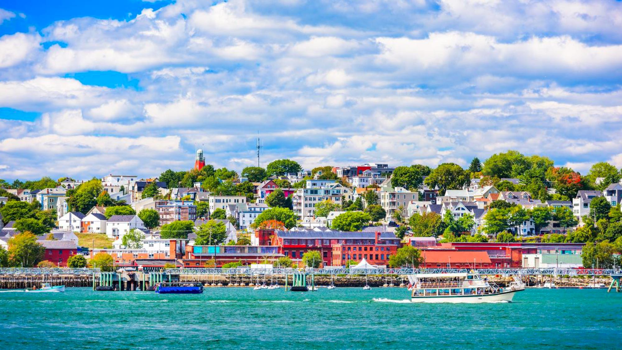 A scenic view of Portland, Maine, showcasing its charming waterfront, historic buildings, and vibrant atmosphere. Portland is a highlight of a journey to Australia, visiting 21 countries, perfect for travelers who fly and own their own airplanes.