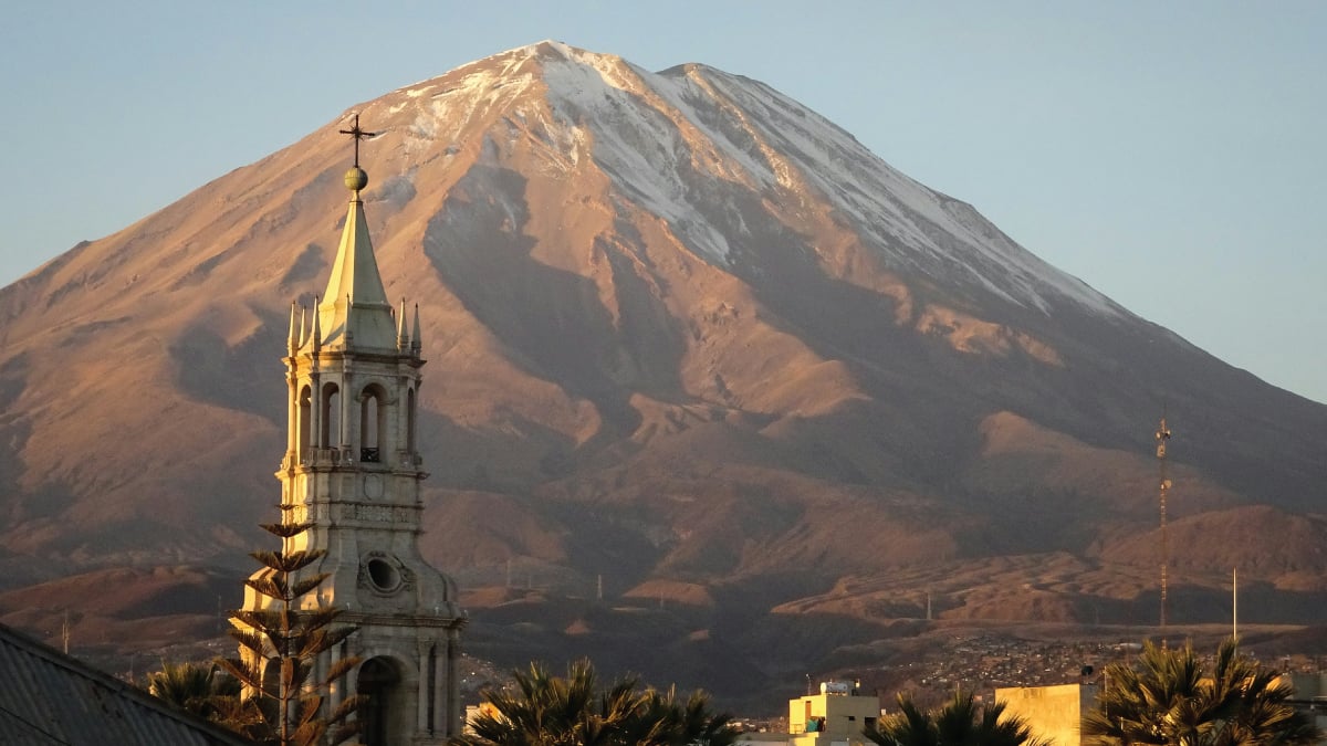 A mesmerizing aerial view of the skyline of Arequipa, Peru, set against the backdrop of the majestic Chila Mountains, showcasing the city's vibrant urban landscape amidst stunning natural scenery. A captivating destination for self-flying pilots exploring South America