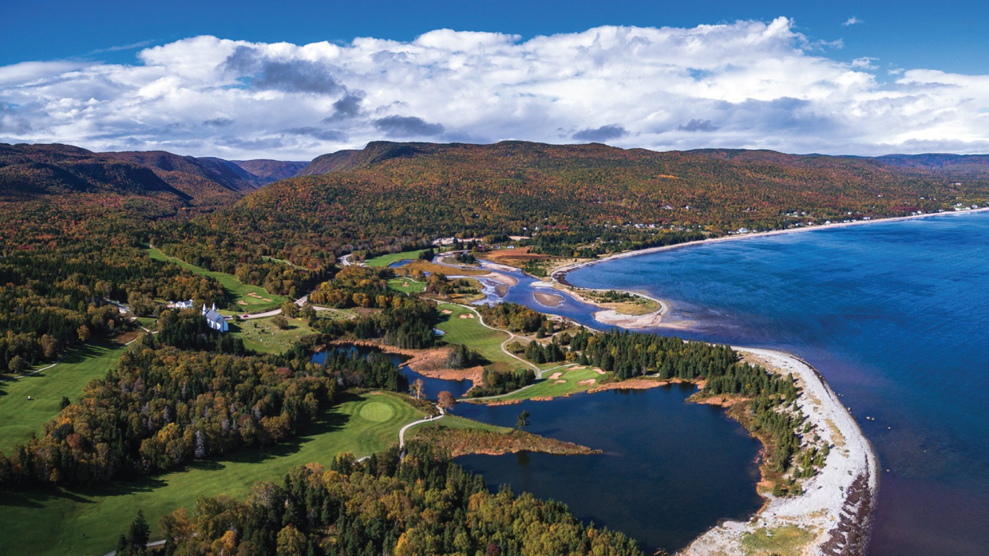 An awe-inspiring aerial view of Cape Breton Island, showcasing its rugged coastline, lush forests, and pristine lakes. Tailored for self-flying pilots