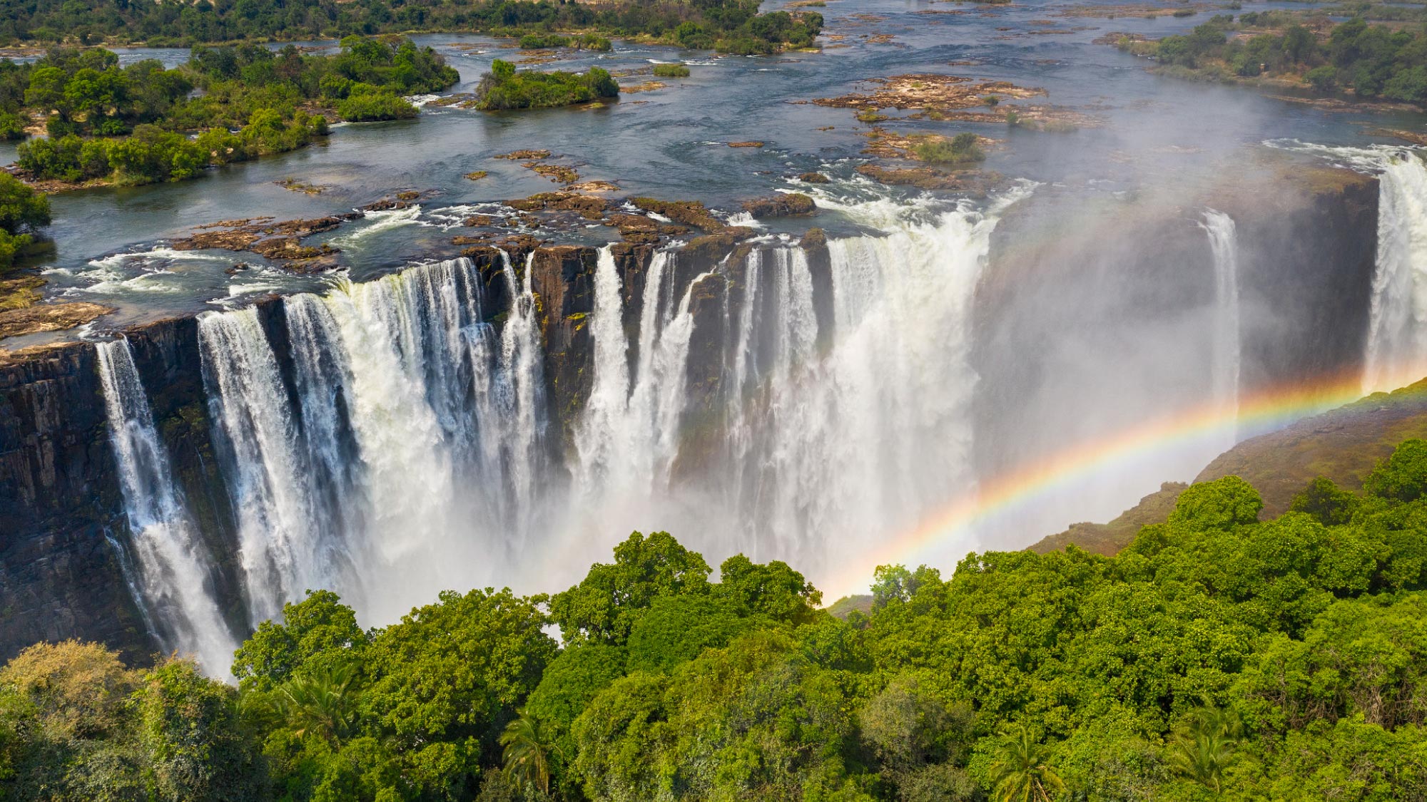 Experience the breathtaking Victoria Falls from above on a pilot's journey, flying over Zambia's stunning landscapes. Take a thrilling helicopter tour and discover the iconic Devil's Pool, where daring adventurers can swim at the edge of the majestic falls.