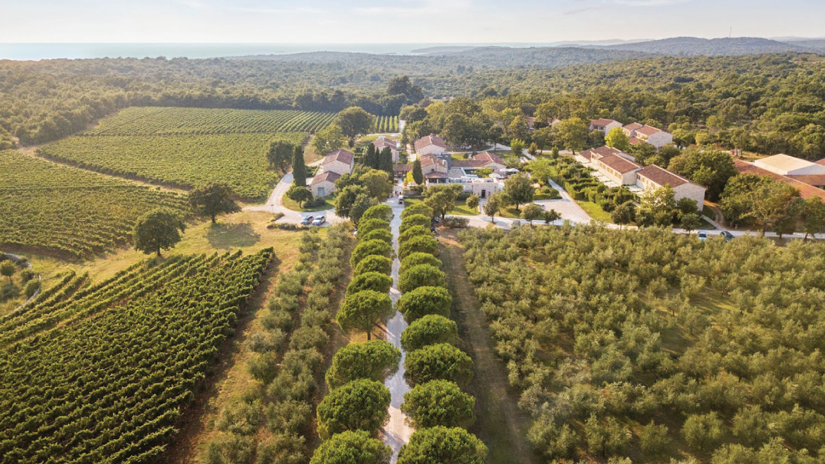 An enchanting aerial view of Meneghetti Wine House & Winery in Pula, Croatia, surrounded by lush vineyards and picturesque countryside. Tailored for self-flying pilots planning a European adventure