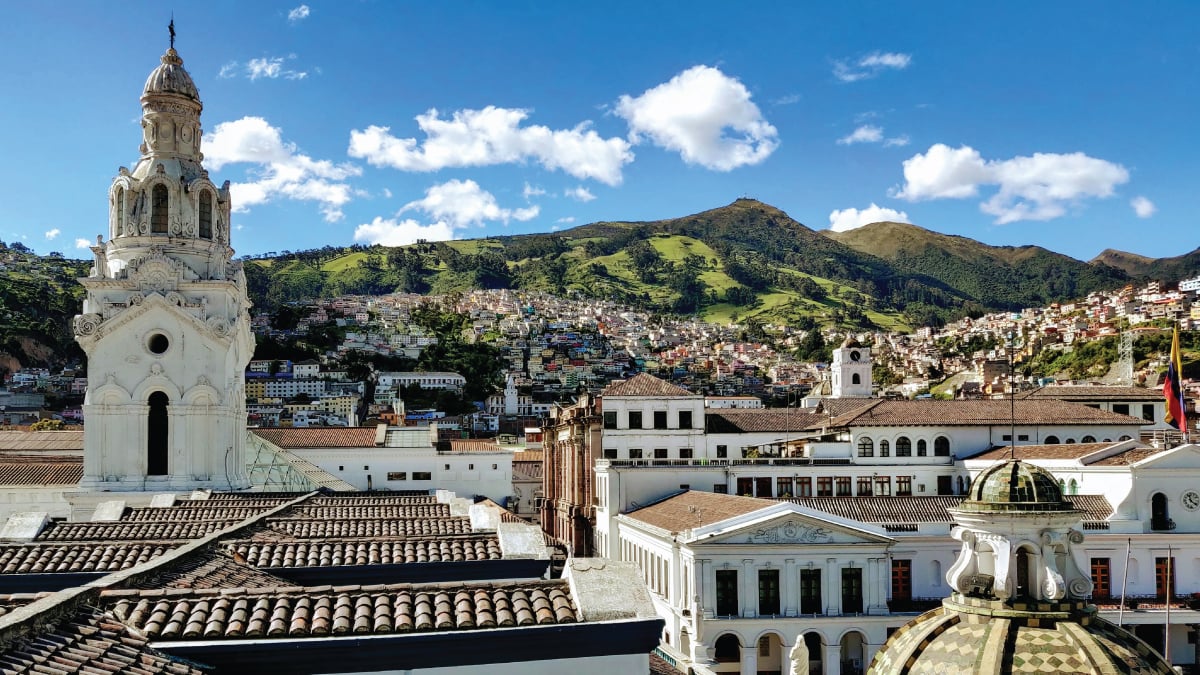 A panoramic view of the captivating skyline of Quito, Ecuador, set against the backdrop of the Andes Mountains. An enticing destination for self-flying pilots embarking on a journey through South America, Quito offers a blend of historic charm, modern vibrancy, and stunning aerial vistas amidst the heights of the Ecuadorian capital.