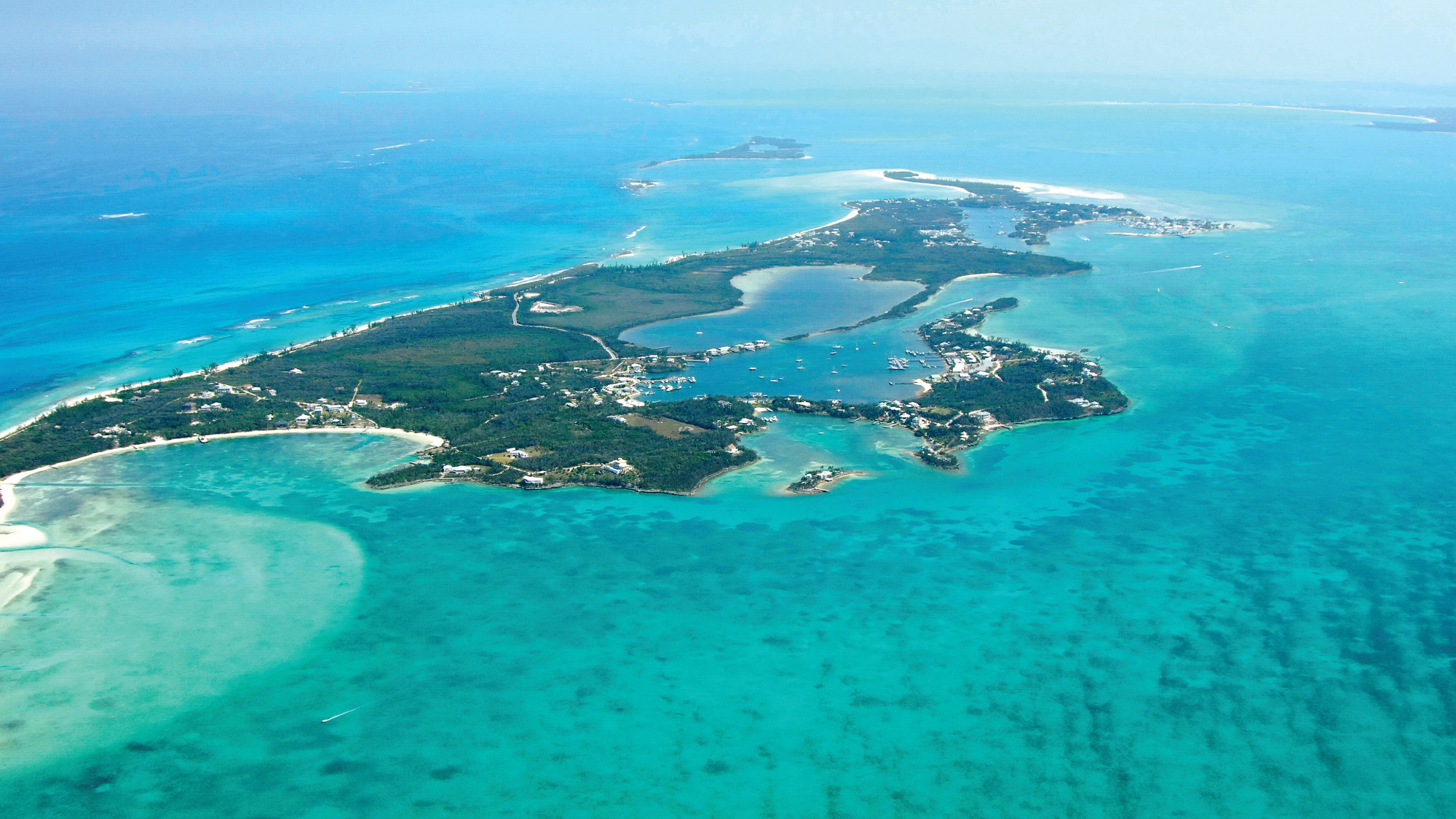 A breathtaking aerial view of Treasure Cay, Bahamas, showcasing turquoise waters and sandy beaches, ideal for self-flying pilots exploring the beautiful Bahamas by air